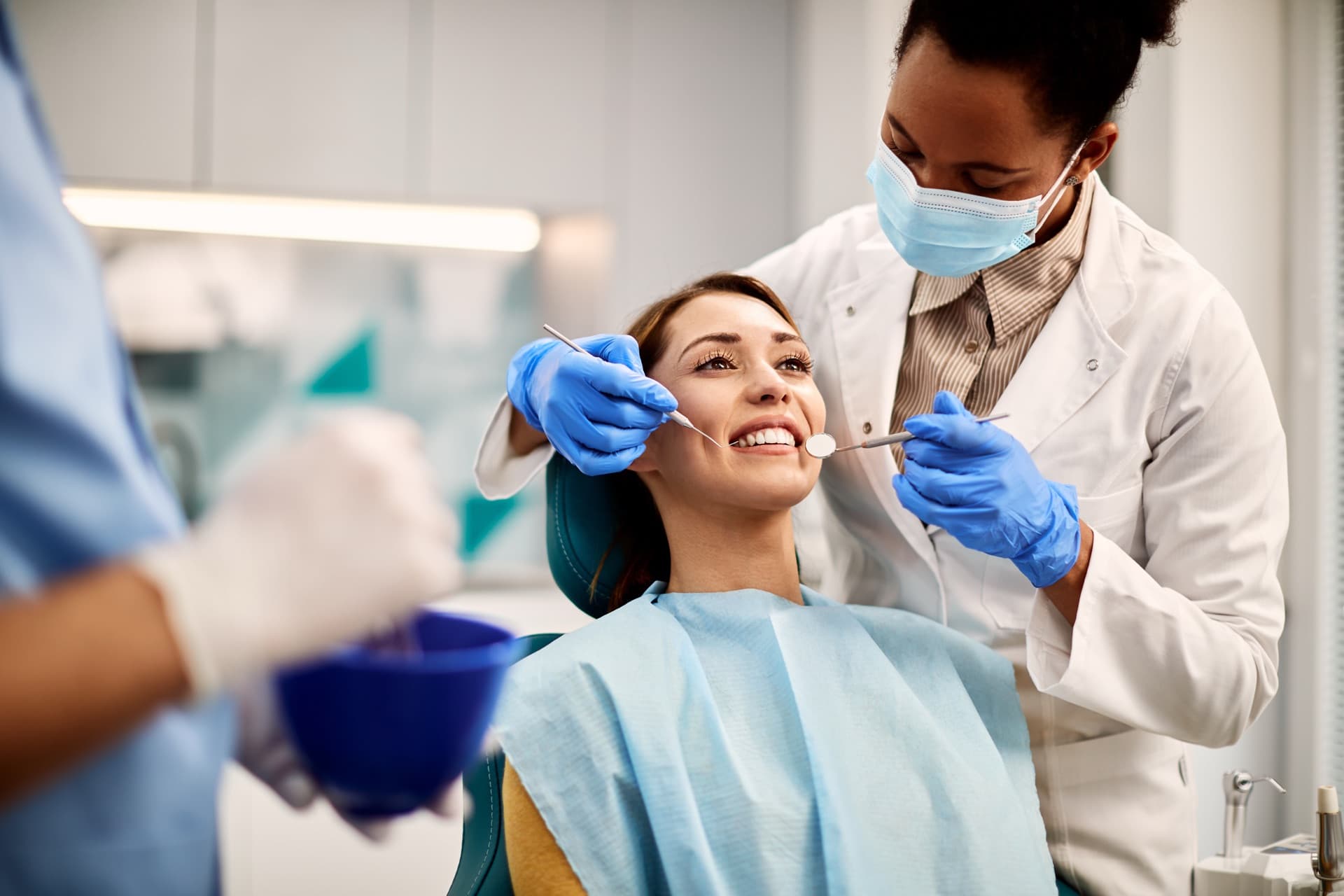 Dentist examining a smiling patient in a bright, contemporary GTA dental clinic